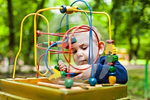 Little kid boy plays with a multicolored logical toy