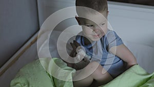 little kid boy preparing to sleep covering his loving toy with green blanket