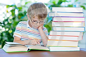 Little kid boy reading book at school