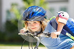 Little kid boy ride a bicycle in the park. Kid cycling on bicycle. Happy smiling child in helmet riding a bike. Boy