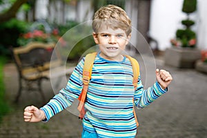 Little kid boy with school satchel on first day to school