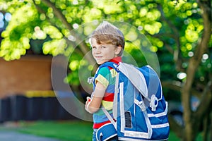 Little kid boy with school satchel on first day to school