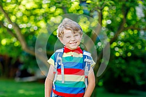 Little kid boy with school satchel on first day to school