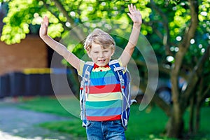 Little kid boy with school satchel on first day to school