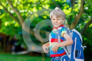 Little kid boy with school satchel on first day to school