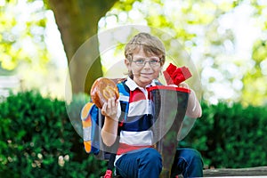 Little kid boy with school satchel on first day to school