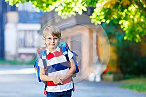 Little kid boy with school satchel on first day to school