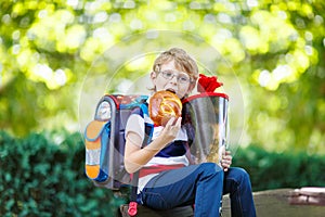 Little kid boy with school satchel on first day to school