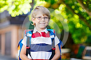Little kid boy with school satchel on first day to school