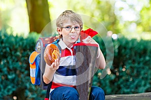 Little kid boy with school satchel on first day to school