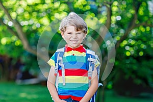 Little kid boy with school satchel on first day to school