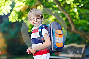 Little kid boy with school satchel on first day to school