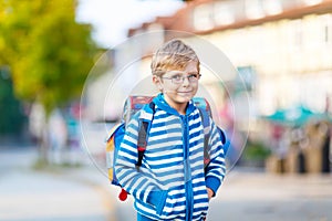 Little kid boy with school satchel on way to school