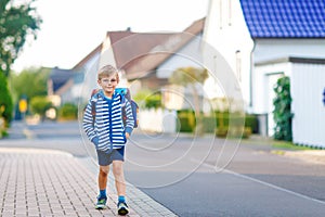 Little kid boy with school satchel on way to school