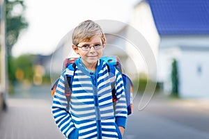 Little kid boy with school satchel on way to school