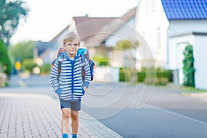 Little kid boy with school satchel on way to school