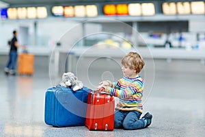 Little kid boy with suitcases on international airport