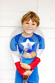 Little kid boy with traditional German school bag in superhero costume