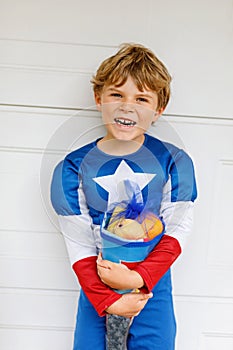 Little kid boy with traditional German school bag in superhero costume