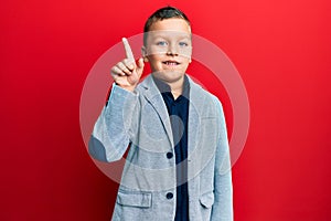 Little kid boy wearing elegant business jacket smiling with an idea or question pointing finger up with happy face, number one
