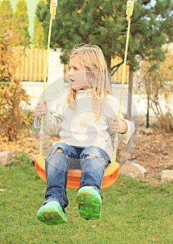 Little kid - disheveled girl on swing