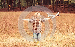 Little kid dreams of being a pilot. Happy boy play airplane. Little boy with plane. Child playing with toy airplane