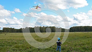 Little kid flying kite in the countryside