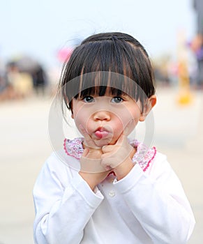 Little kid girl expression funny face. Portrait outdoors
