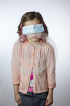 Little kid girl with the eyes closed by mask during coronavirus epidemy