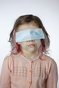 Little kid girl with the eyes closed by mask during coronavirus epidemy
