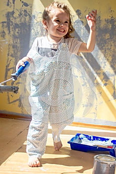 Little kid girl helping making renovation at house room.