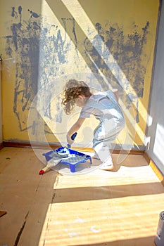 Little kid girl helping making renovation at house room.