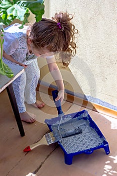 Little kid girl helping making renovation at house room.