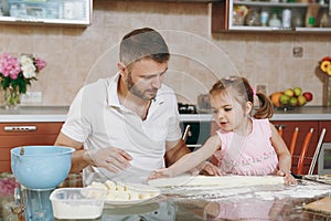 Little kid girl helps man to cook lazy dumplings, forming dough at table. Happy family dad, child daughter cooking food