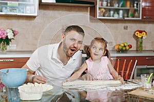 Little kid girl helps man to cook lazy dumplings, forming dough at table. Happy family dad, child daughter cooking food