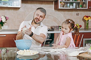 Little kid girl helps man to cook lazy dumplings preparing dough at table. Happy family dad, child daughter cooking food