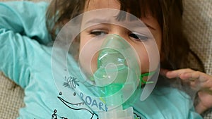 Little kid girl making inhalation with nebulizer at home. Child asthma inhaler inhalation nebulizer sick cough concept