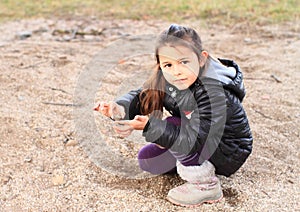 Little kid - girl playing in sand