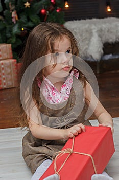 Little kid girl with the red christmas box gift at hands.