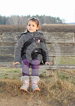 Little kid - girl sitting on a bench