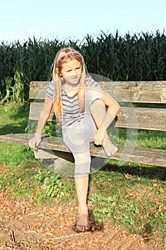 Little kid - girl sitting on a bench