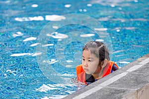 Little kid girl swimming in outdoor pool, kids swimming in pool