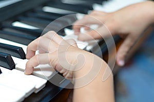 Little kid hand playing keyboard close-up