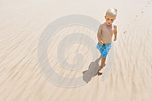 Little kid have fun, run by sand beach