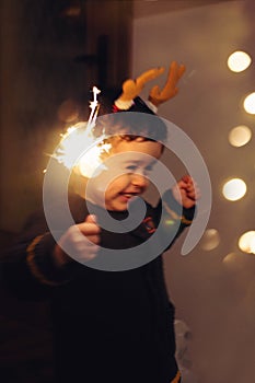 Little kid holding sparkle stick, dancing with joy