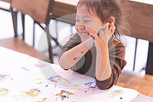 Little kid laughing while getting messy with art work creativ