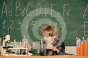 Little kid learning chemistry in school laboratory. school kid scientist studying science. Little boy at the elementary