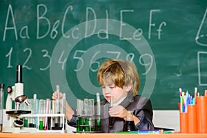 Little kid learning chemistry in school laboratory. school kid scientist studying science. Little boy at the elementary