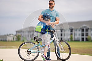 Little kid learning to ride bicycle with father in park. Father teaching son cycling. Father and son learning to ride a