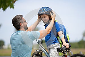 Little kid learning to ride bicycle with father in park. Father teaching son cycling. Father and son learning to ride a